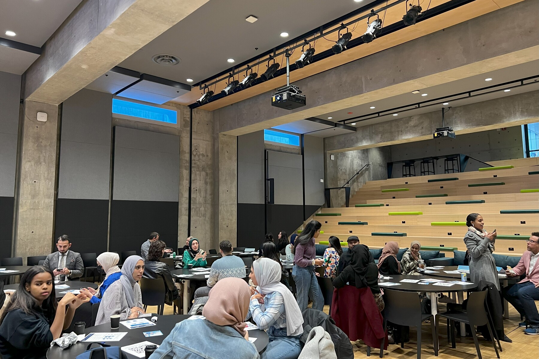 People at a number of round tables engaged in conversation