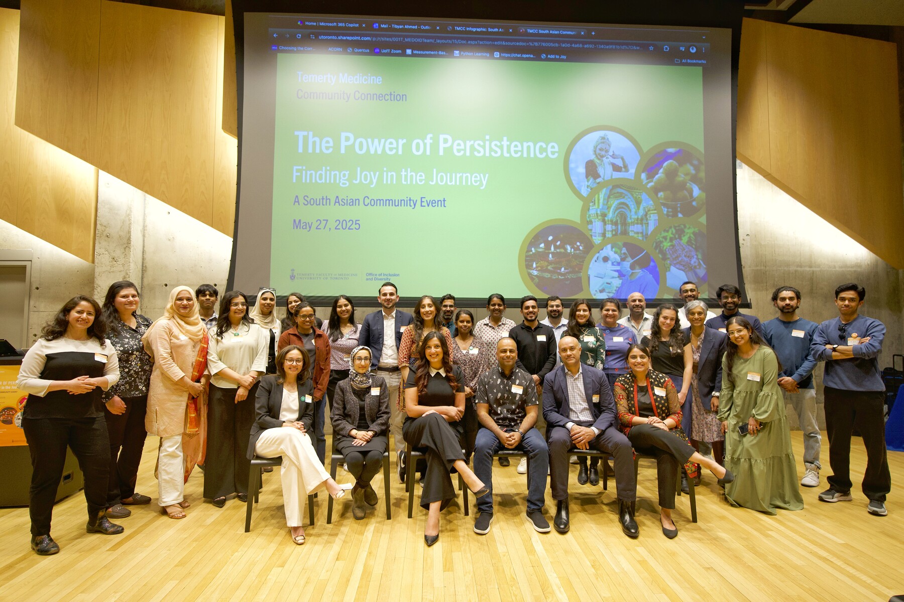 A large group of people arranged in three rows posing for a photo in front of a screen that reads "The Power of Persistence: Finding Joy in the Journey."