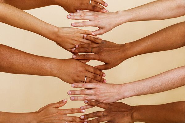 a collection of hands and arms of different skin tones reaching out to touch each other