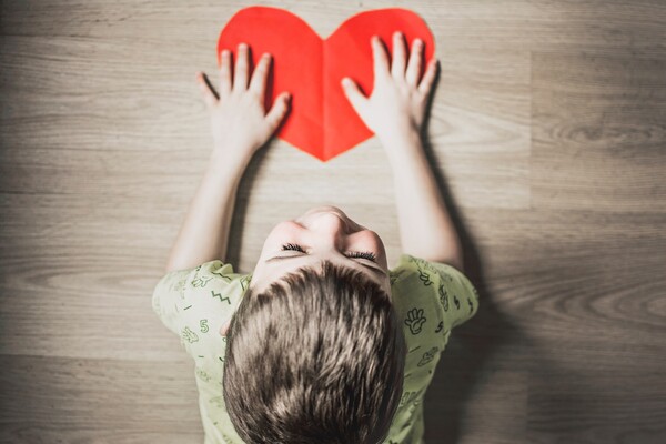 child holding cut out picture of a heart