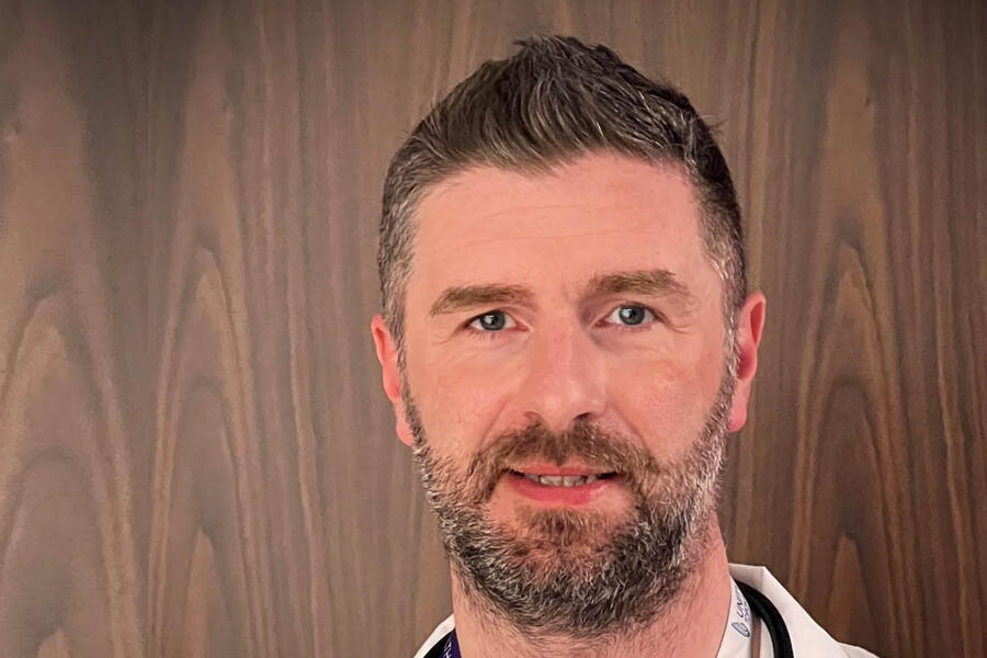 a man with a light brown beard in a white lab coat