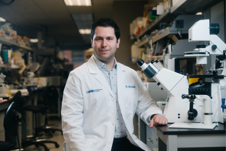 Brian Ballios stands at a counter in his lab, facing the camera