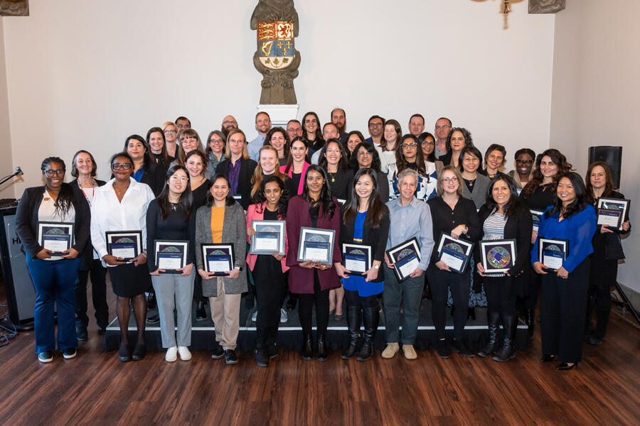 A group of about 50 people holding certificates and smiling.