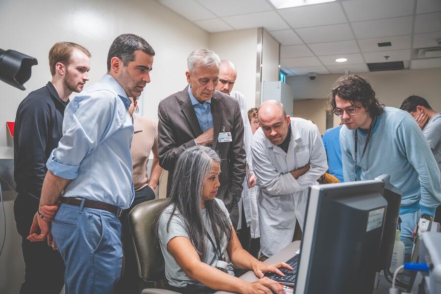Research team gathered around a computer screen.