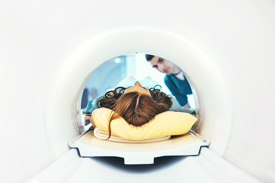 The top of a woman's head is seen from the inside of an MRI machine. 