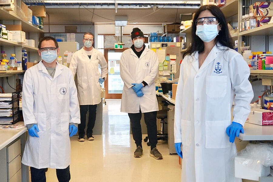 researchers in the lab wearing protective equipment and masks