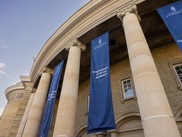 Exterior view of Convocation Hall decorated with blue banners that say, "Congratulations to all our graduates."