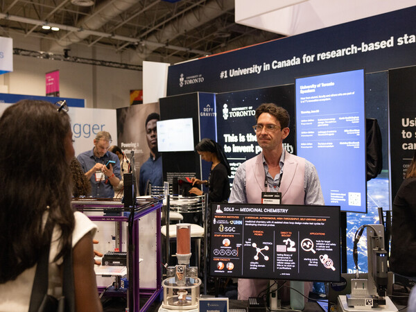 A man stands at a display at the 2024 Collision conference in Toronto.