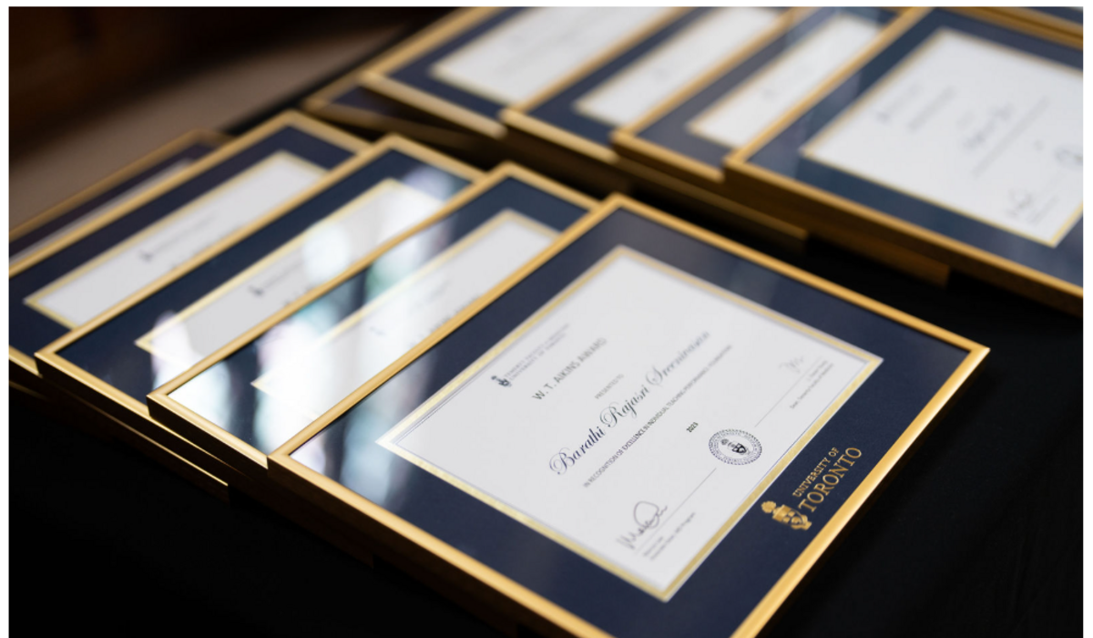 Frame award certificates are laid out on a table.