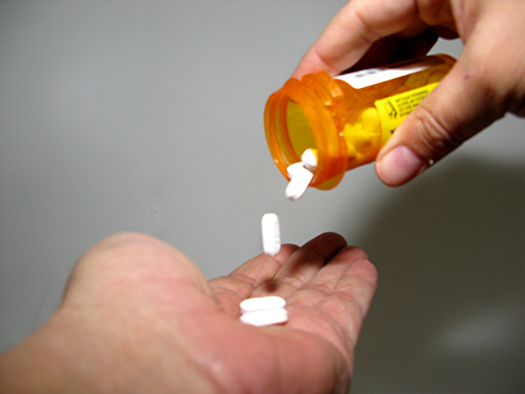 Pills emerging from bottle.