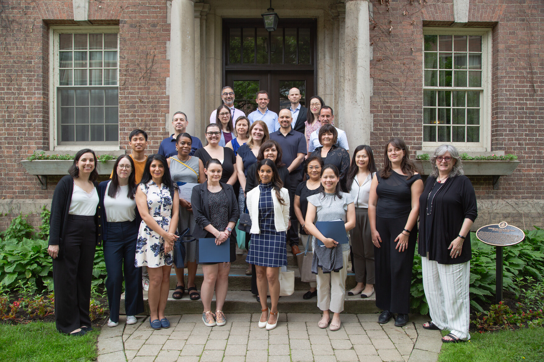 Staff mentors and and mentees stand for a photo outside the Faculty Club