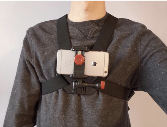 An unidentifiable person wears a chest-mounted smartphone
