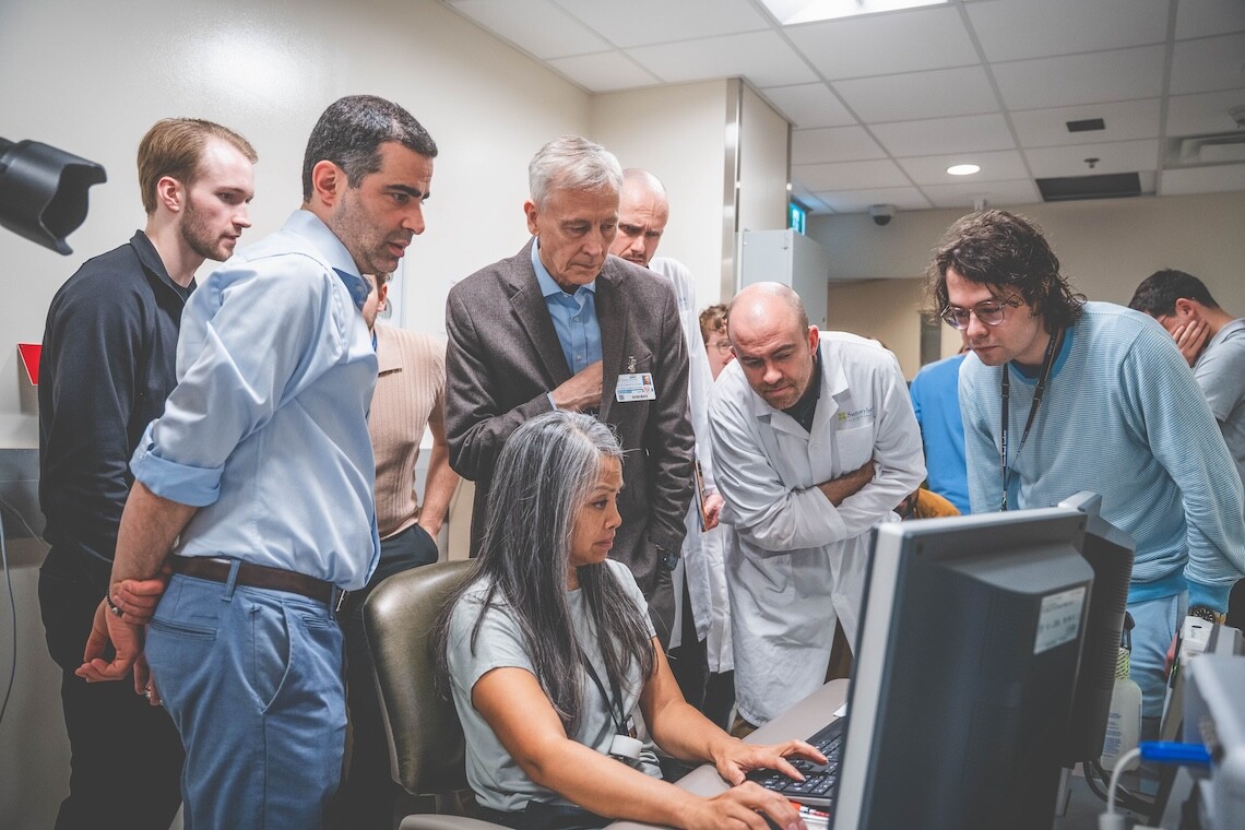 Research team gathered around a computer screen.