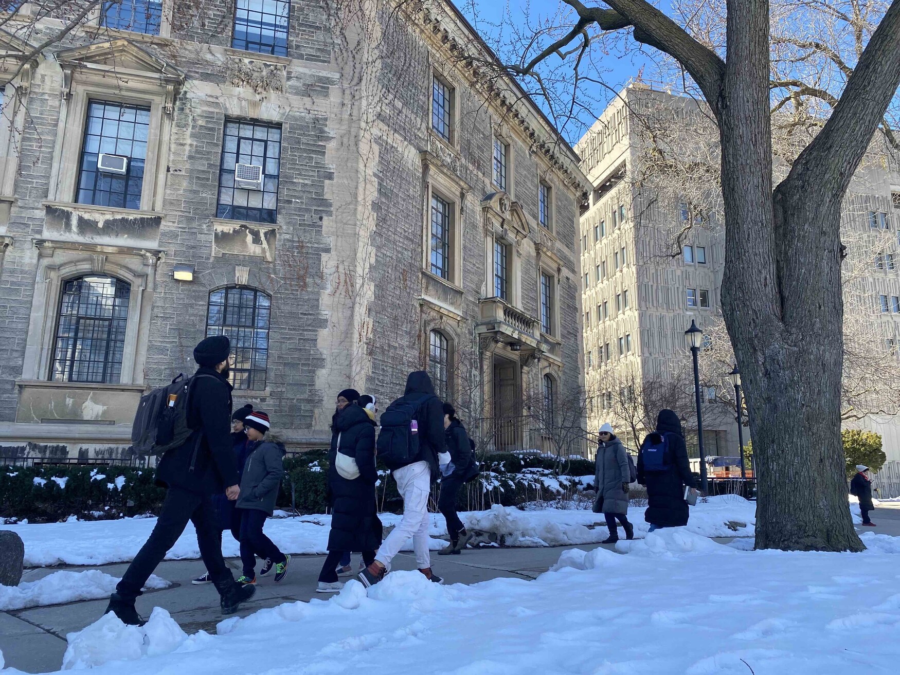 People walking outside the Naylor and Medical Sciences Buildings on a clear winter day.