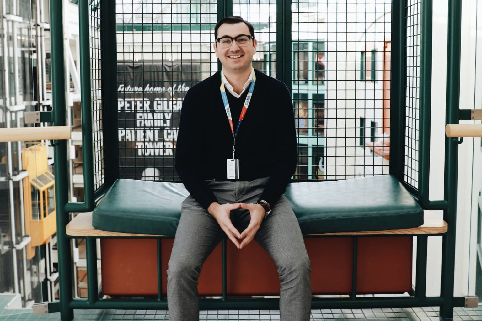 A man sits on a bench in a hospital