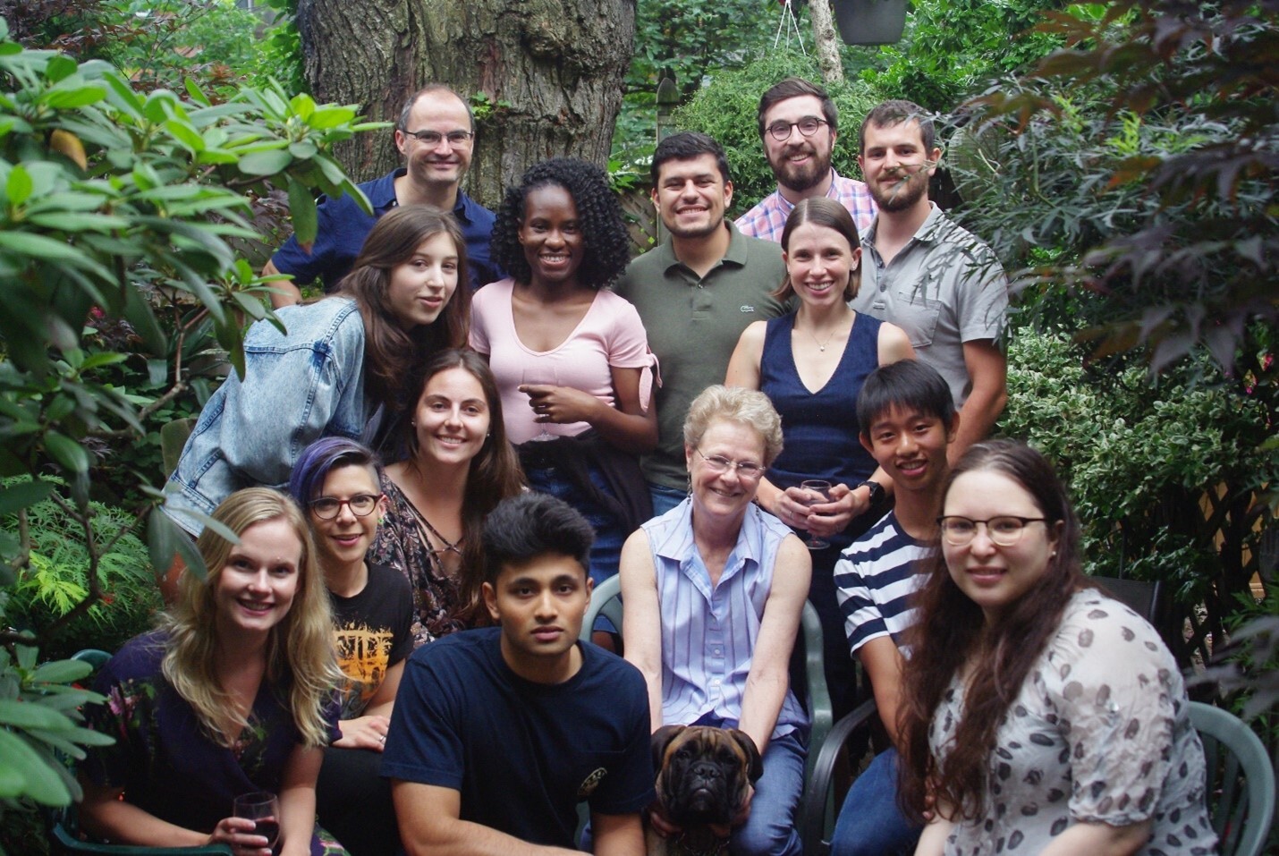 Patricia Brubaker seated outside, surrounded by her trainees and lab staff