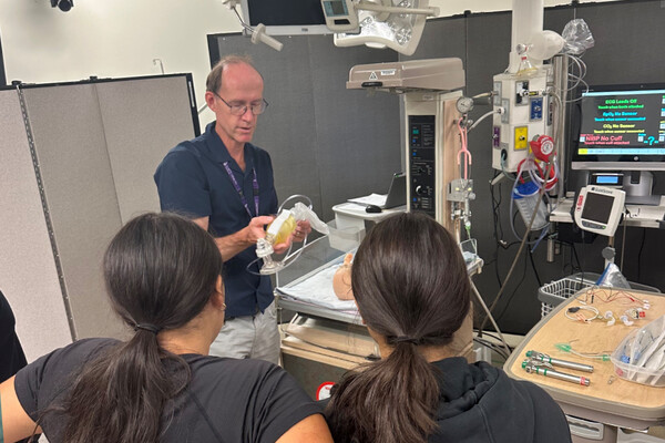 Professor Doug Campbell leads a simulation session with high school students as part of the ZNBGK program