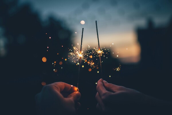 Two sparklers amid a night sky. Photo by Ian Schneider on Unsplash