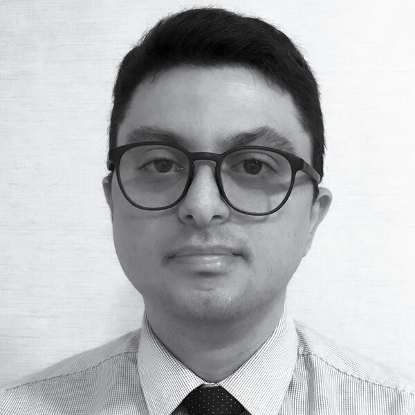 a black and white portrait of a researcher in a collared shirt and tie