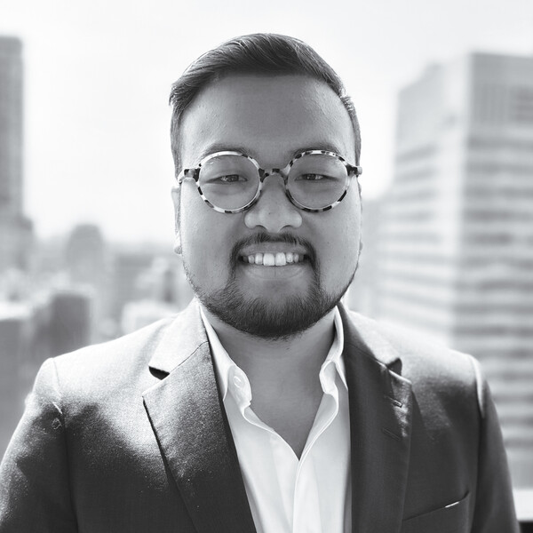 a black and white portrait of a researcher in a collared shirt and jacket