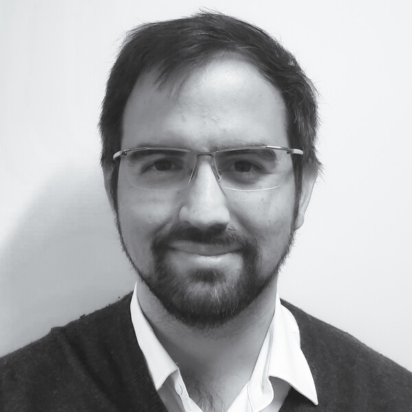 a black and white portrait of a researcher in a collared shirt and sweater