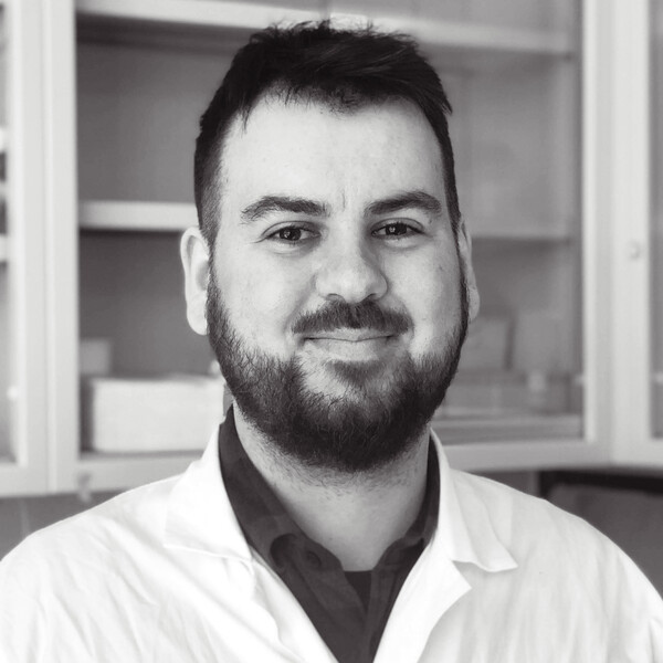 a black and white portrait of a researcher in a white lab coat