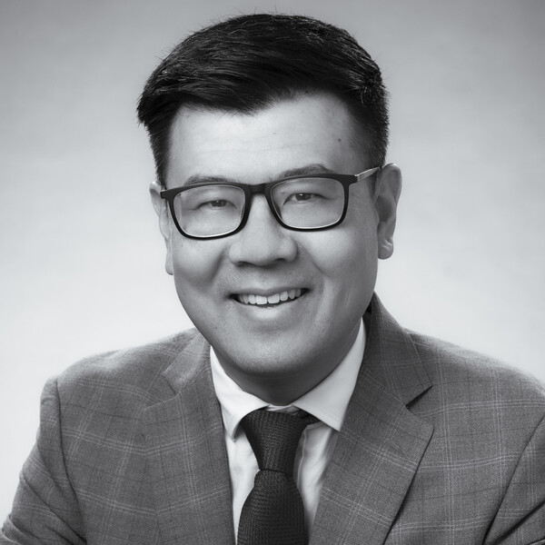 a black and white portrait of a researcher wearing a checkered suit and tie