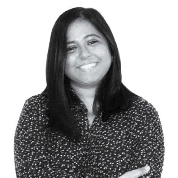 A black and white photo of a scientist wearing a polka-dot shirt