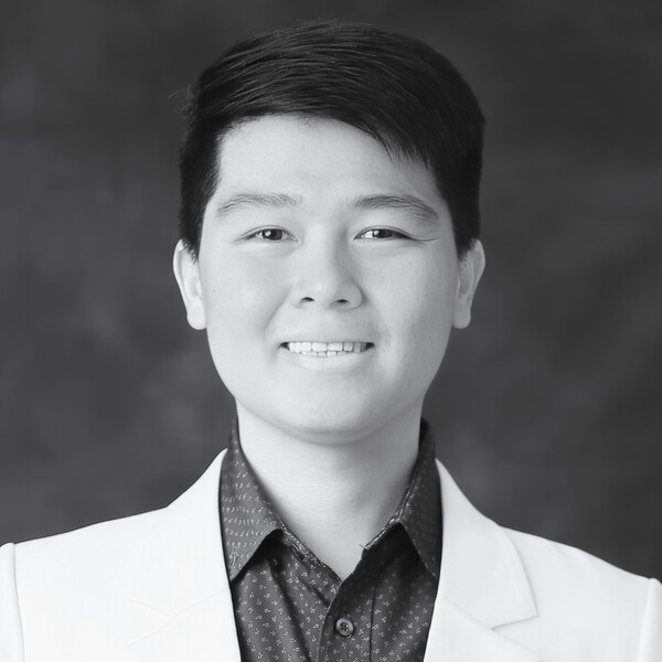 a black and white photo of a researcher with short black hair wearing a white jacket