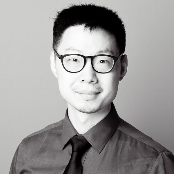 A black and white photo of a researcher in a collared shirt and tie