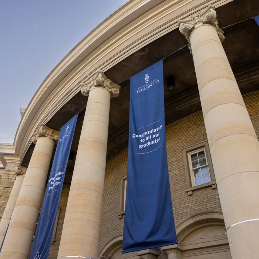 Exterior view of Convocation Hall decorated with blue banners that say, "Congratulations to all our graduates."