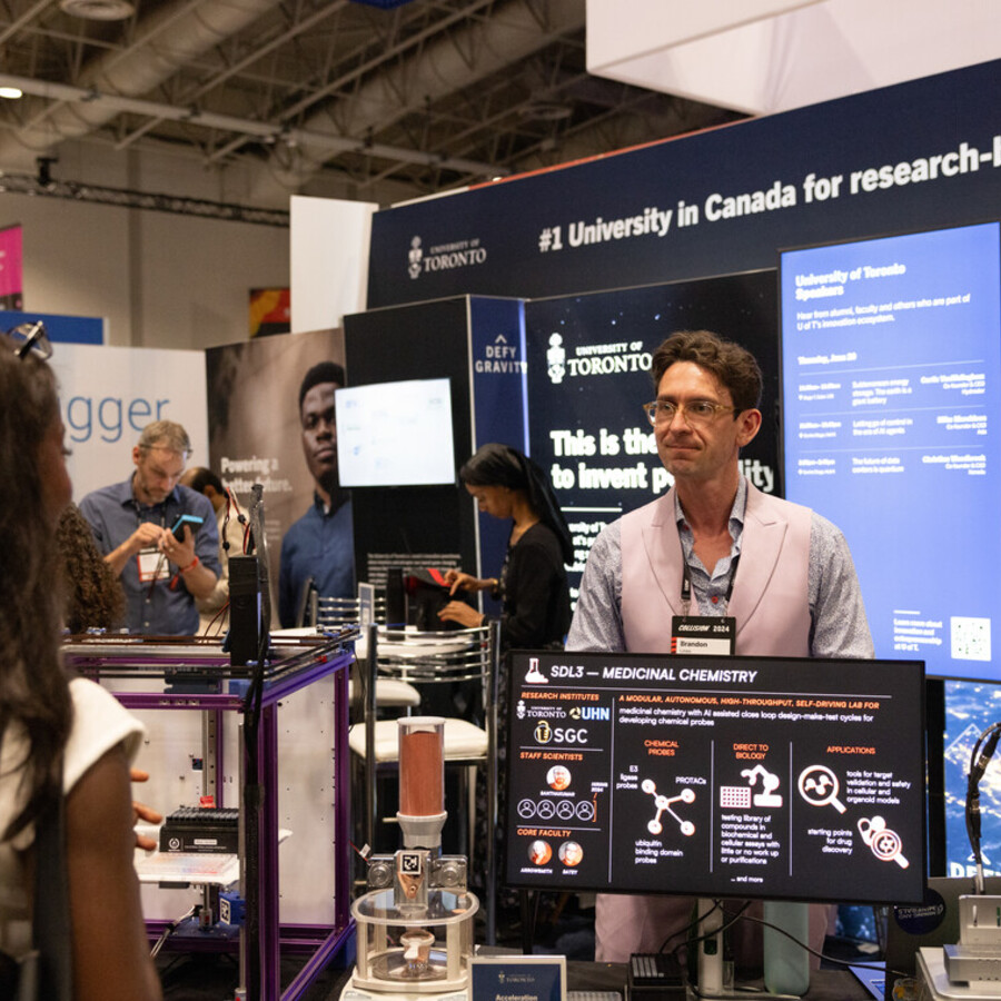 A man stands at a display at the 2024 Collision conference in Toronto.